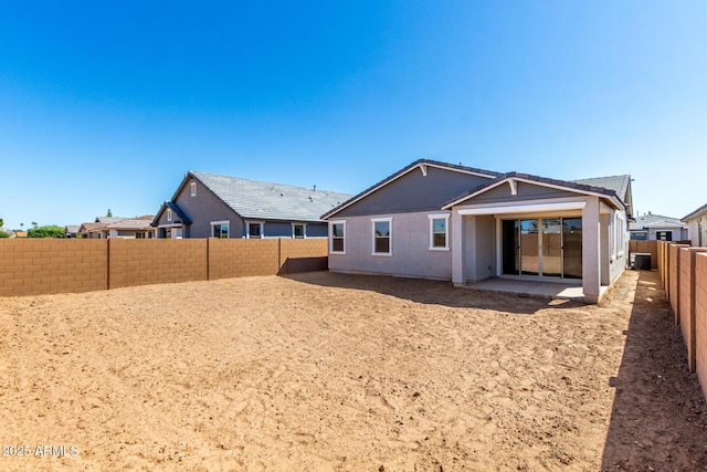 rear view of property featuring a fenced backyard and a patio area