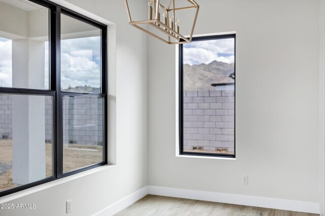 26655 S 169th Pl, Queen Creek, AZ 85142 - empty room with wood finished floors, baseboards, and an inviting chandelier