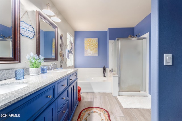 full bathroom featuring a sink, a stall shower, wood finished floors, and double vanity