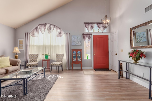 entrance foyer with a notable chandelier, baseboards, light wood-type flooring, and visible vents