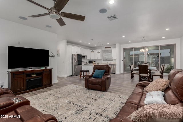 935 Calle Azul, Wickenburg, AZ 85390 - living room featuring recessed lighting, ceiling fan with notable chandelier, visible vents, baseboards, and light wood-type flooring