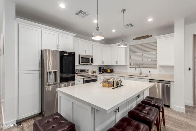 935 Calle Azul, Wickenburg, AZ 85390 - kitchen featuring stainless steel appliances, a sink, a kitchen breakfast bar, light countertops, and pendant lighting