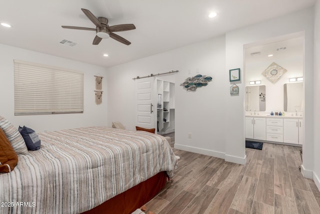 935 Calle Azul, Wickenburg, AZ 85390 - bedroom featuring light wood-type flooring, a barn door, visible vents, and baseboards