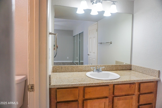 bathroom with vanity, a notable chandelier, and toilet