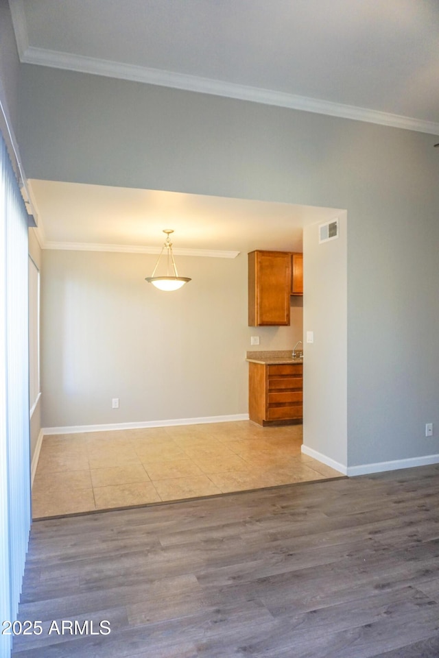 spare room with light hardwood / wood-style floors and crown molding