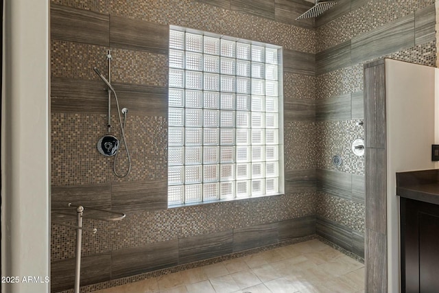 bathroom featuring tile patterned flooring and tiled shower