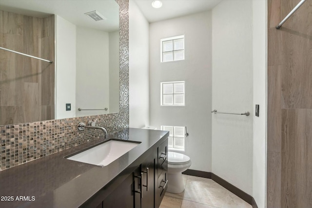 bathroom with toilet, vanity, decorative backsplash, and tile patterned floors