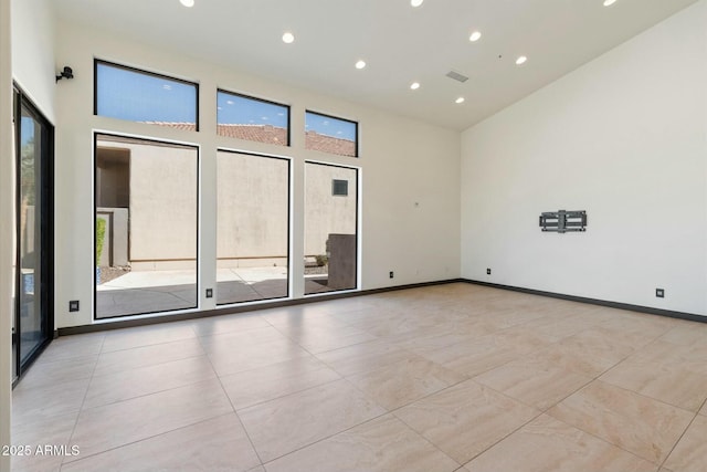 empty room with a towering ceiling and a healthy amount of sunlight