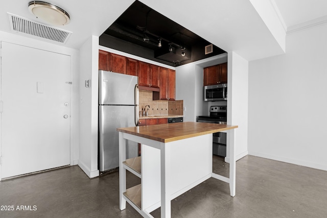 kitchen with concrete floors, visible vents, appliances with stainless steel finishes, butcher block counters, and decorative backsplash
