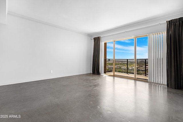 unfurnished room featuring concrete floors, baseboards, and ornamental molding