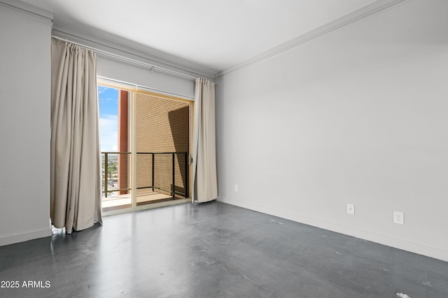 spare room featuring concrete flooring, baseboards, and crown molding