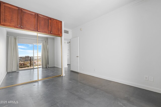 interior space with visible vents, baseboards, concrete flooring, and crown molding