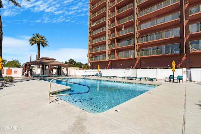 community pool featuring a gazebo, a patio area, and fence