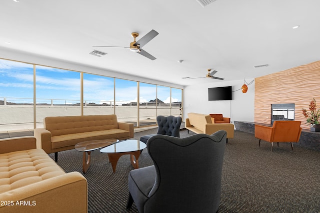living room featuring carpet flooring, visible vents, and a ceiling fan