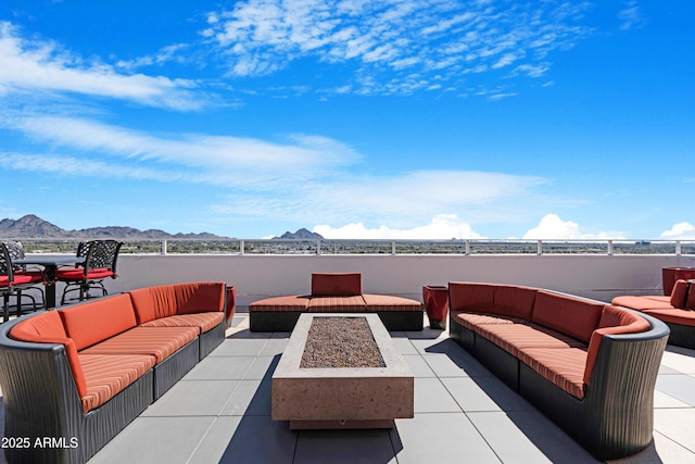 view of patio featuring an outdoor living space with a fire pit and a mountain view