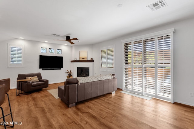 living room featuring wood-type flooring and ceiling fan