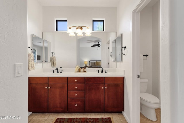 bathroom with tile flooring, ceiling fan, toilet, and dual vanity