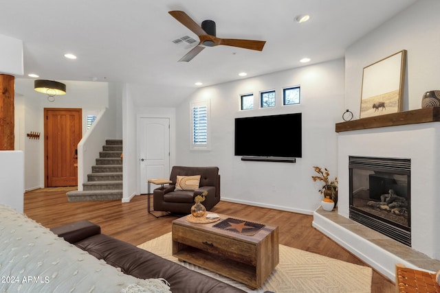 living room featuring light hardwood / wood-style flooring, ceiling fan, and lofted ceiling