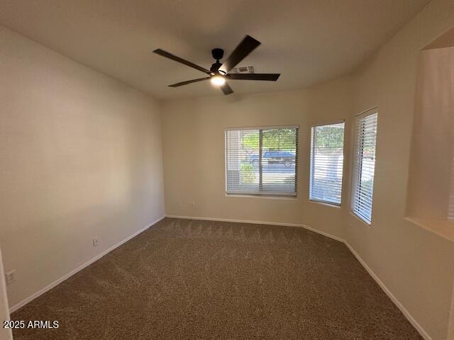20985 N 81st Dr, Peoria, AZ 85382 - empty room featuring ceiling fan, dark carpet, and baseboards