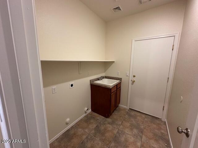 20985 N 81st Dr, Peoria, AZ 85382 - laundry area featuring electric dryer hookup, cabinet space, dark tile patterned flooring, and baseboards