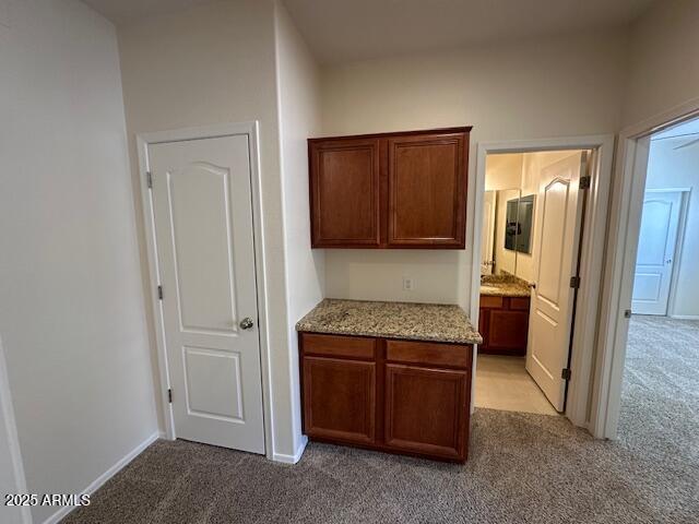 20985 N 81st Dr, Peoria, AZ 85382 - kitchen with light carpet, light stone counters, and baseboards