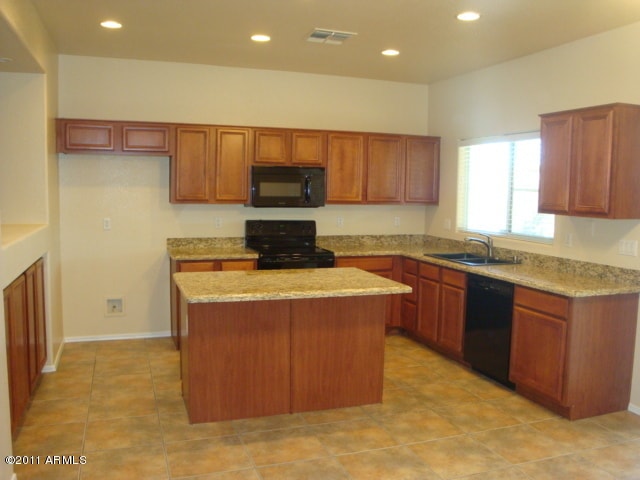 20985 N 81st Dr, Peoria, AZ 85382 - kitchen with black appliances, a sink, a center island, recessed lighting, and brown cabinets