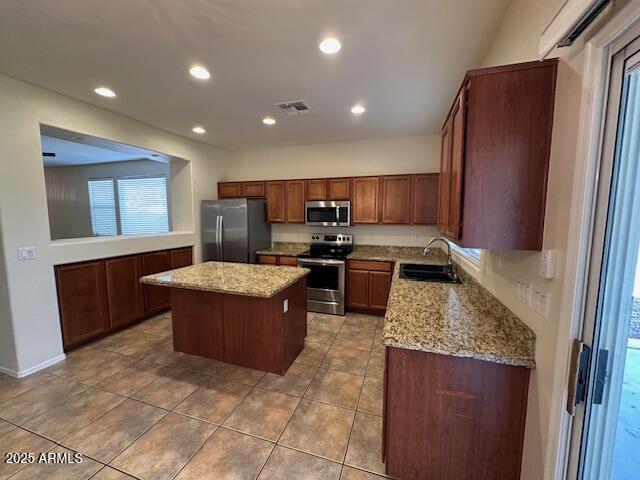 20985 N 81st Dr, Peoria, AZ 85382 - kitchen with stainless steel appliances, a sink, a center island, recessed lighting, and light stone countertops