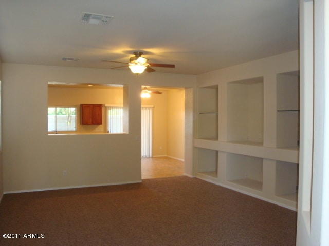 20985 N 81st Dr, Peoria, AZ 85382 - spare room featuring ceiling fan, carpet floors, and baseboards