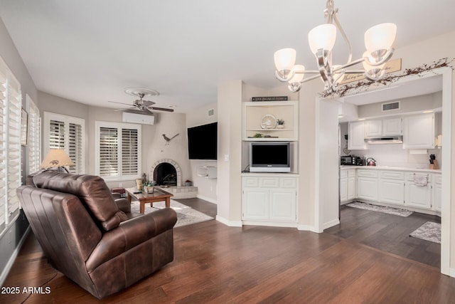 living room with dark hardwood / wood-style floors and ceiling fan with notable chandelier