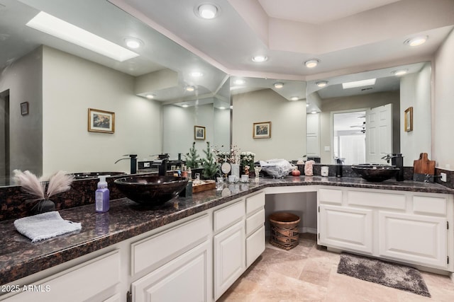 bathroom featuring vanity, a skylight, and ceiling fan