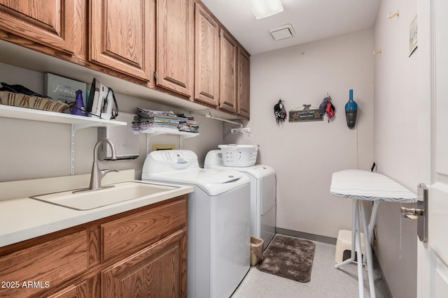 laundry room with cabinets, sink, and washer and clothes dryer