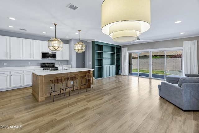 1272 W Joshua Tree Ave, Queen Creek, AZ 85140 - kitchen featuring appliances with stainless steel finishes, open floor plan, light countertops, white cabinetry, and recessed lighting