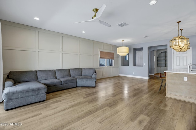 1272 W Joshua Tree Ave, Queen Creek, AZ 85140 - living room with a decorative wall, light wood-style floors, a ceiling fan, recessed lighting, and baseboards
