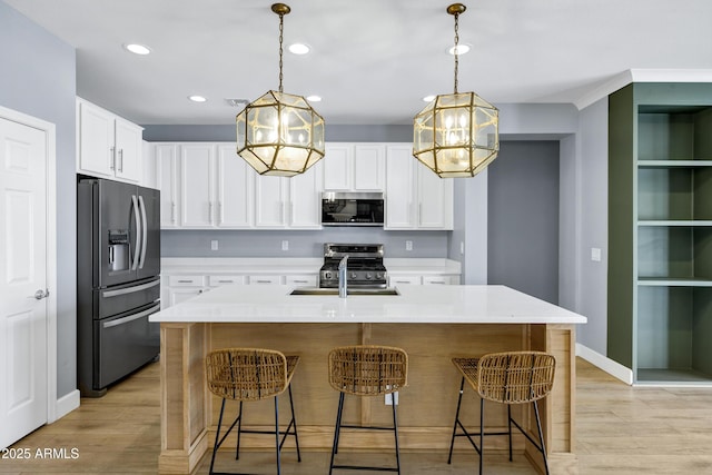 1272 W Joshua Tree Ave, Queen Creek, AZ 85140 - kitchen with stainless steel appliances, light wood-style flooring, a kitchen breakfast bar, light countertops, and recessed lighting