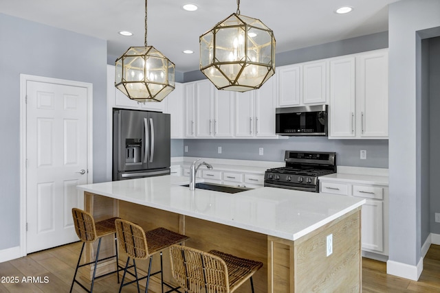 1272 W Joshua Tree Ave, Queen Creek, AZ 85140 - kitchen featuring appliances with stainless steel finishes, a sink, a chandelier, light wood-style floors, and recessed lighting