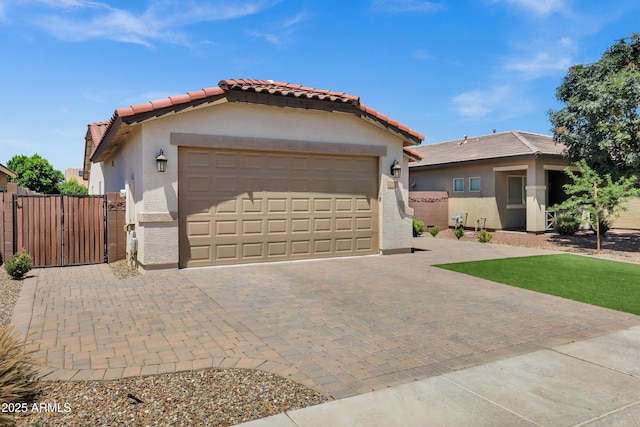 1272 W Joshua Tree Ave, Queen Creek, AZ 85140 - view of front of home with a tile roof, stucco siding, a gate, decorative driveway, and an attached garage