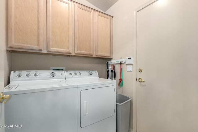 clothes washing area featuring cabinets and independent washer and dryer