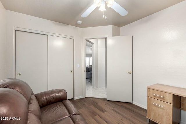 living room featuring dark wood-type flooring and ceiling fan