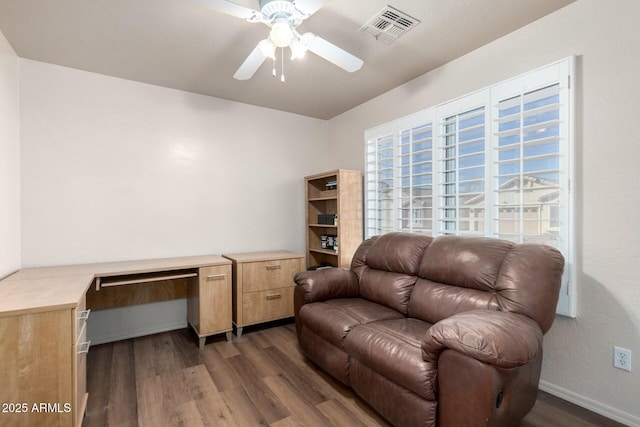 sitting room with ceiling fan, built in desk, and dark hardwood / wood-style flooring