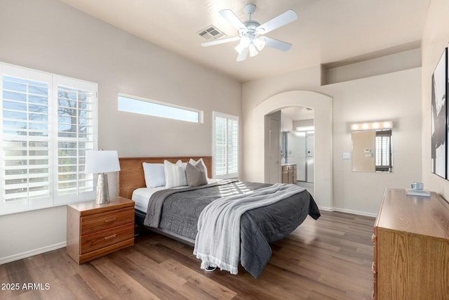 bedroom featuring connected bathroom, hardwood / wood-style floors, and ceiling fan