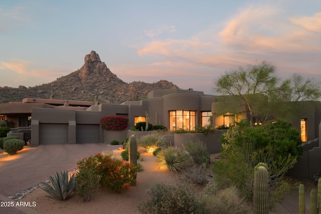 10040 E Happy Valley Rd Unit 1011, Scottsdale, AZ 85255 - pueblo revival-style home featuring a garage, stucco siding, decorative driveway, a mountain view, and fence