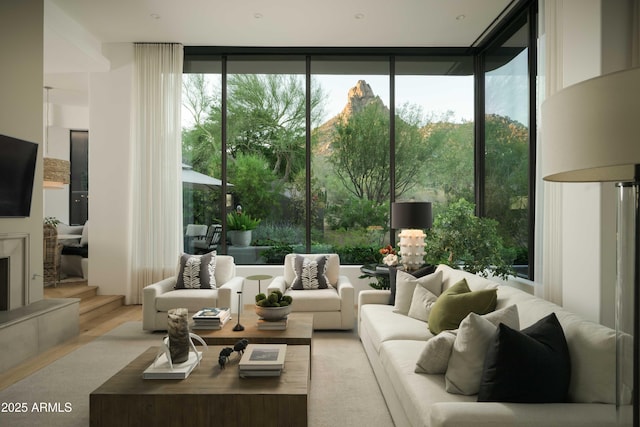 10040 E Happy Valley Rd Unit 1011, Scottsdale, AZ 85255 - living room featuring floor to ceiling windows, wood finished floors, and a high end fireplace