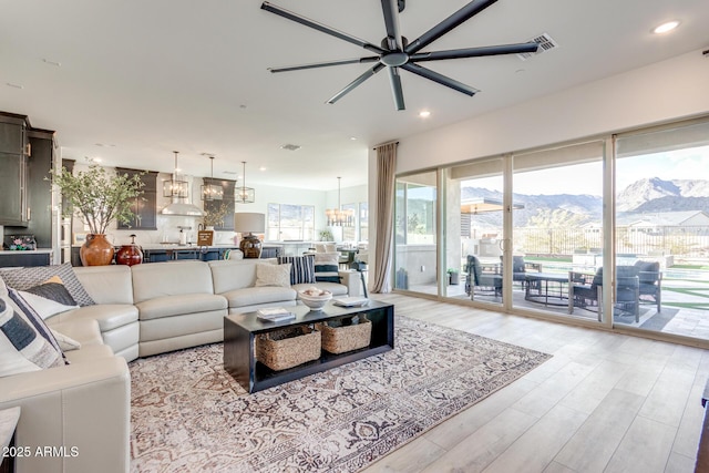 living area featuring a mountain view, recessed lighting, visible vents, a ceiling fan, and light wood finished floors