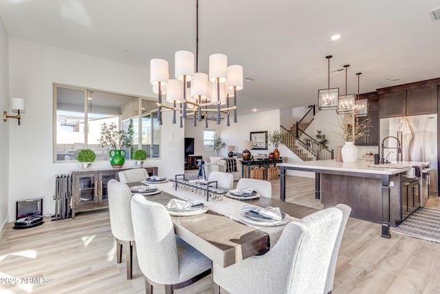 dining area featuring visible vents, light wood-style flooring, stairway, a chandelier, and recessed lighting