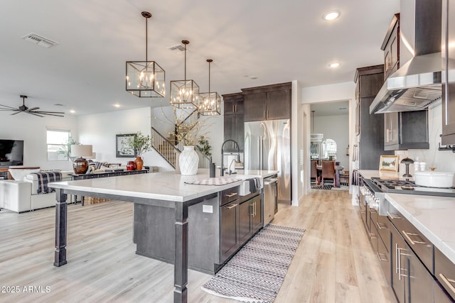 kitchen featuring pendant lighting, a breakfast bar area, a spacious island, open floor plan, and exhaust hood