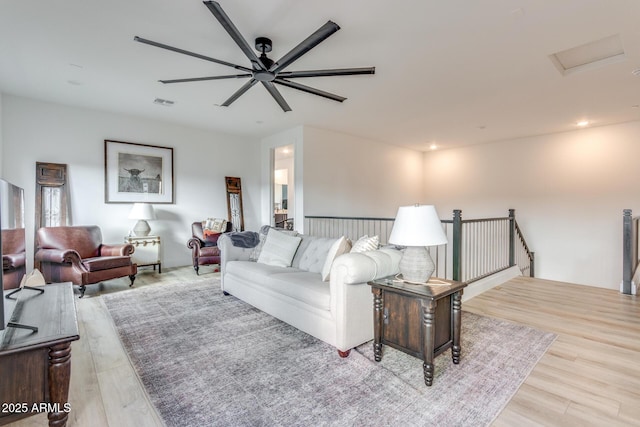 living room featuring light wood finished floors, attic access, visible vents, and recessed lighting