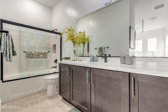 bathroom featuring shower / bath combination with glass door, vanity, visible vents, and tile patterned floors