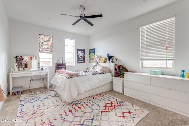 bedroom featuring multiple windows, a ceiling fan, and light colored carpet