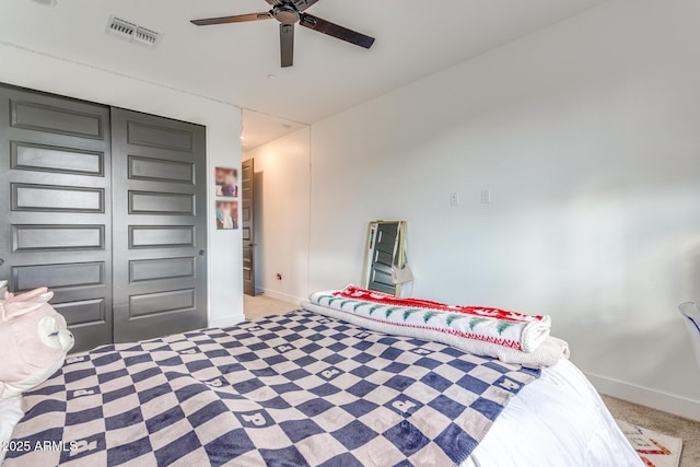 bedroom with a ceiling fan, visible vents, light carpet, and baseboards