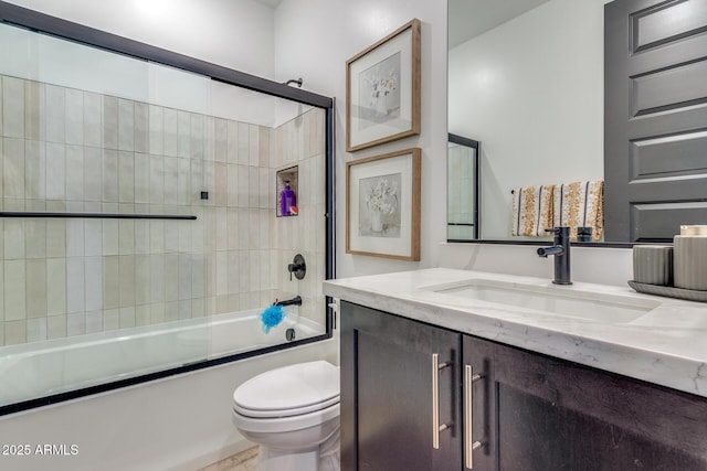 bathroom featuring combined bath / shower with glass door, vanity, and toilet